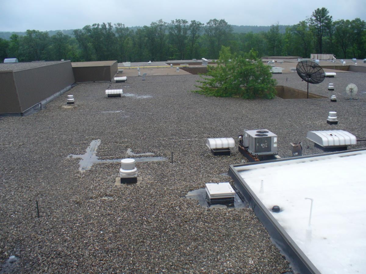 Commercial flat roof with gravel ballast and rooftop HVAC units