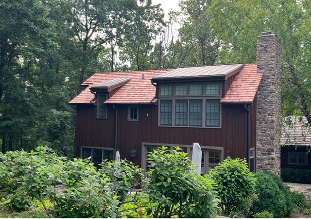 Standing seam metal roof with cedar shake accent on a modern home
