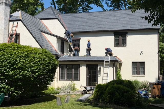 Nu-Fix crew installing a slate roof on a stucco Tudor-style home