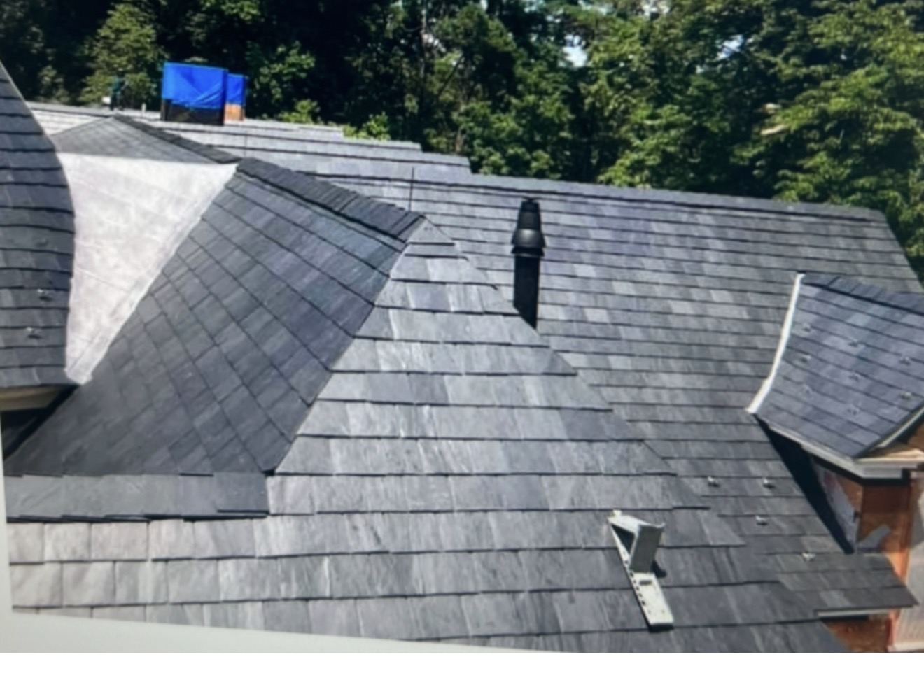 Aerial view of a new slate roof with multiple dormers