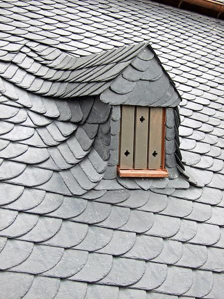 Detail of scalloped slate roofing around a dormer window